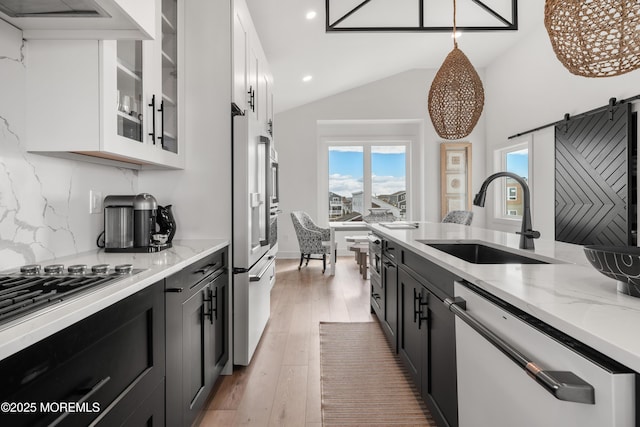 kitchen featuring sink, white cabinetry, dishwasher, and decorative light fixtures