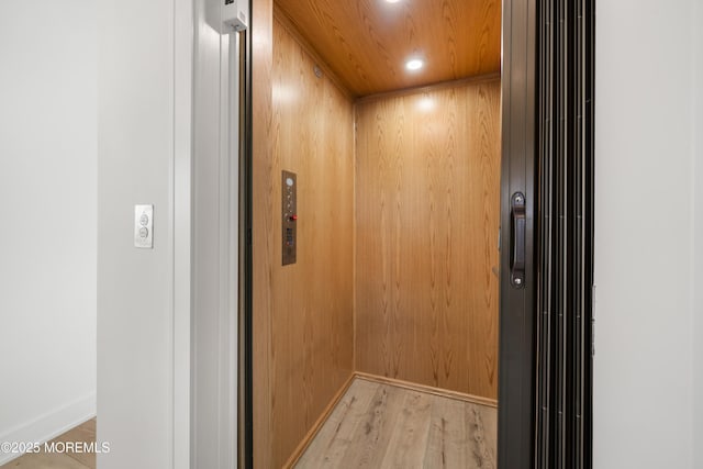 room details featuring elevator, hardwood / wood-style floors, wooden walls, and wood ceiling