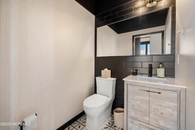 bathroom featuring backsplash, toilet, tile walls, and vanity