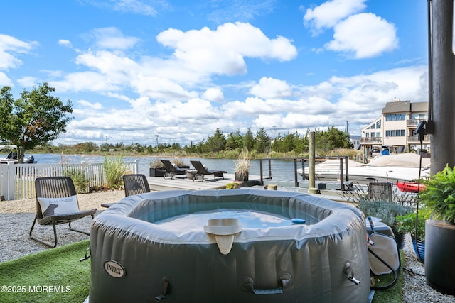 view of swimming pool with a jacuzzi and a water view