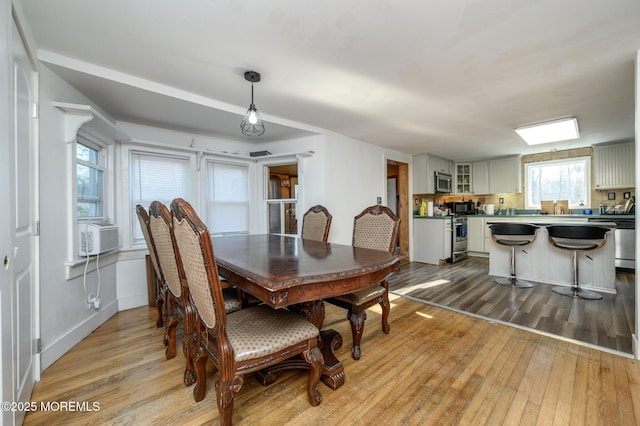 dining room with cooling unit and light wood-type flooring