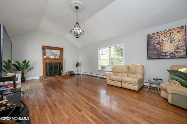 living room with lofted ceiling, wood-type flooring, a fireplace, and a baseboard heating unit