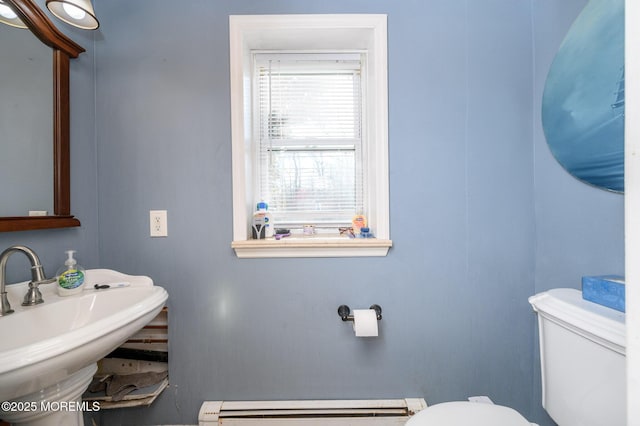 bathroom featuring a baseboard heating unit, sink, and toilet