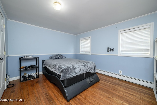 bedroom with dark wood-type flooring, ornamental molding, and baseboard heating