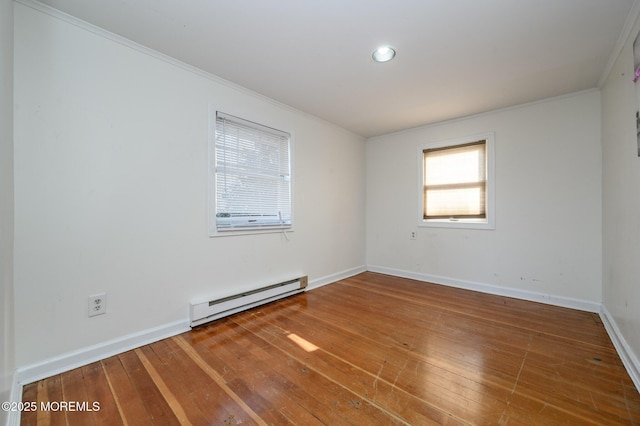 spare room with crown molding, hardwood / wood-style floors, and baseboard heating