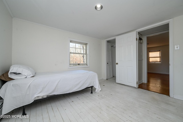 bedroom with multiple windows and light wood-type flooring