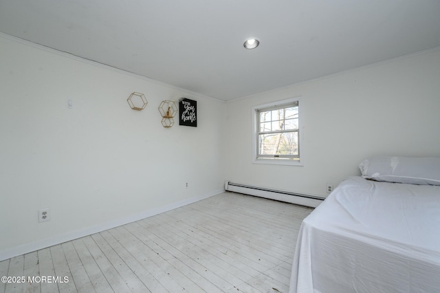 unfurnished bedroom with a baseboard heating unit, crown molding, and light hardwood / wood-style flooring