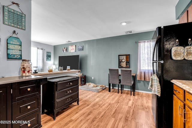 interior space featuring black refrigerator, a healthy amount of sunlight, and light wood-type flooring