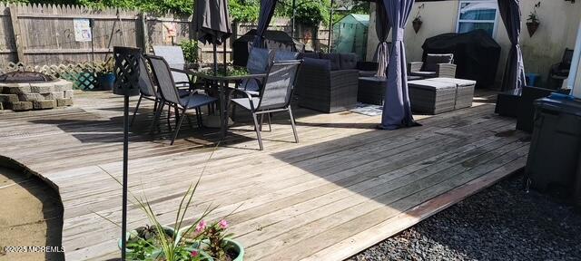 wooden deck featuring a grill and an outdoor fire pit