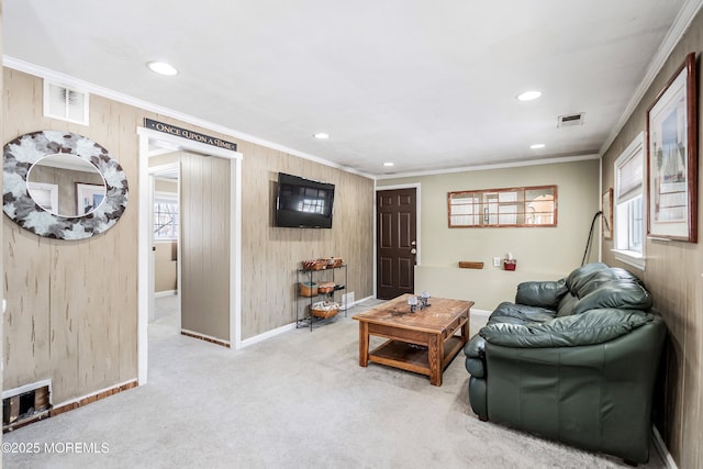 living room with crown molding, carpet flooring, and wooden walls