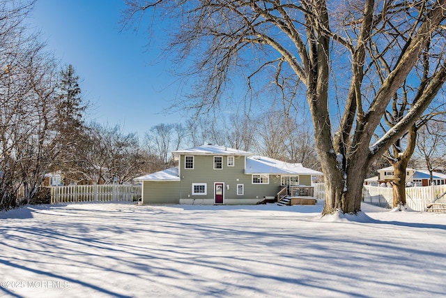 snow covered house with fence