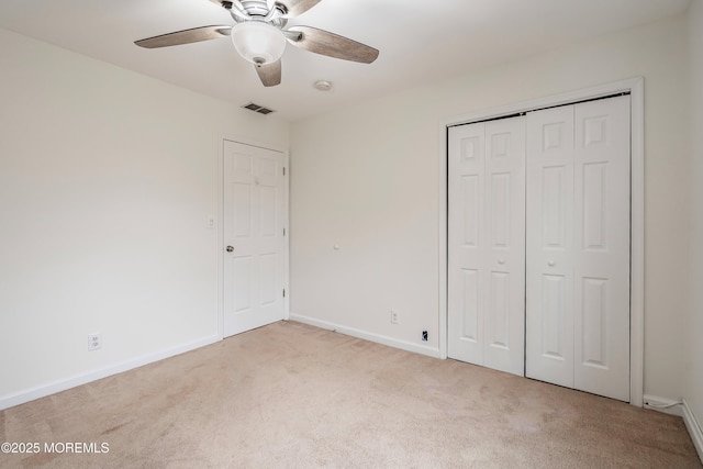 unfurnished bedroom featuring ceiling fan, a closet, and light carpet