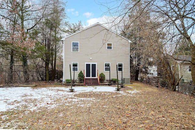 snow covered back of property featuring central AC