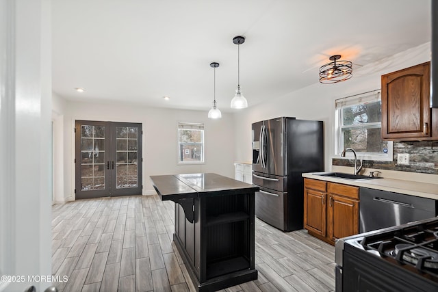 kitchen with stainless steel refrigerator with ice dispenser, french doors, sink, a center island, and gas stove