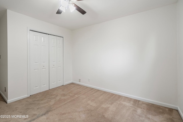 unfurnished bedroom with light carpet, a closet, and ceiling fan