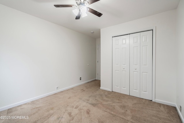 unfurnished bedroom with ceiling fan, a closet, and light carpet