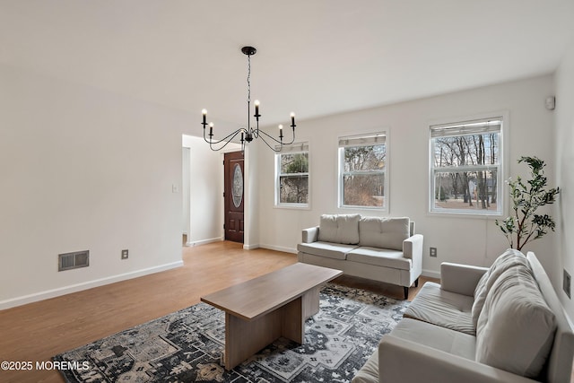 living room with wood-type flooring and a notable chandelier