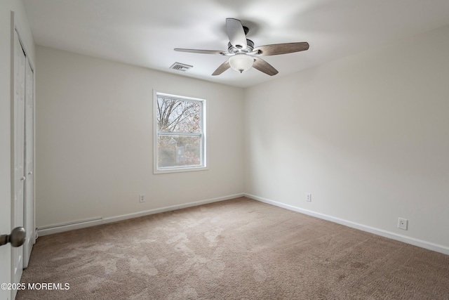 carpeted spare room with ceiling fan