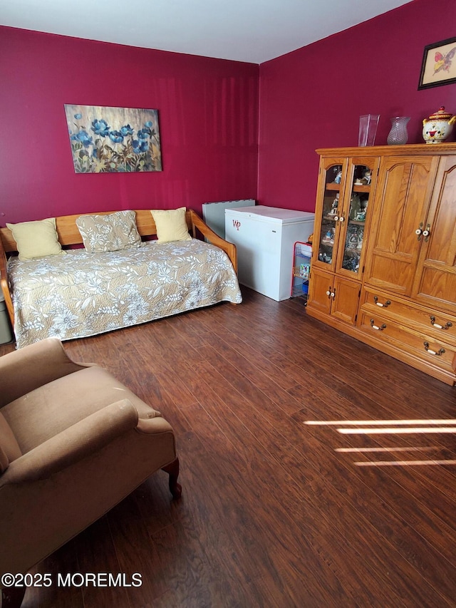 bedroom with dark wood-type flooring