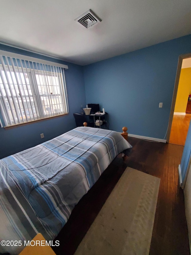 bedroom with dark hardwood / wood-style flooring