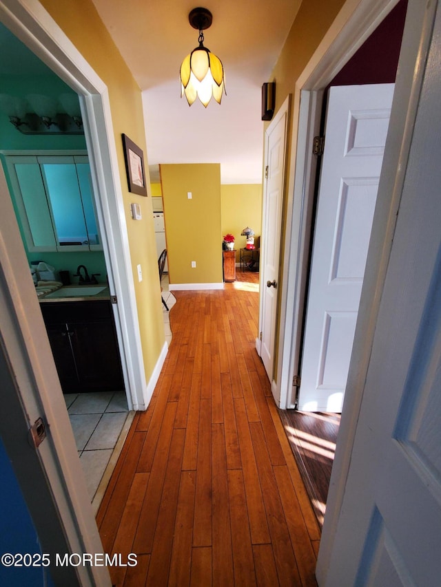 hall with light wood-type flooring and sink