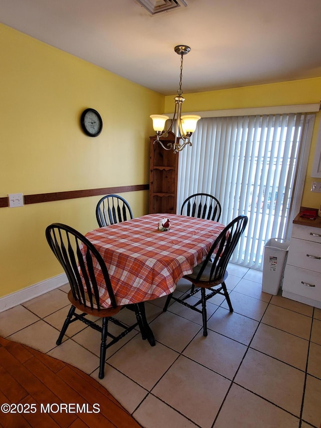 dining room featuring light tile patterned floors and an inviting chandelier