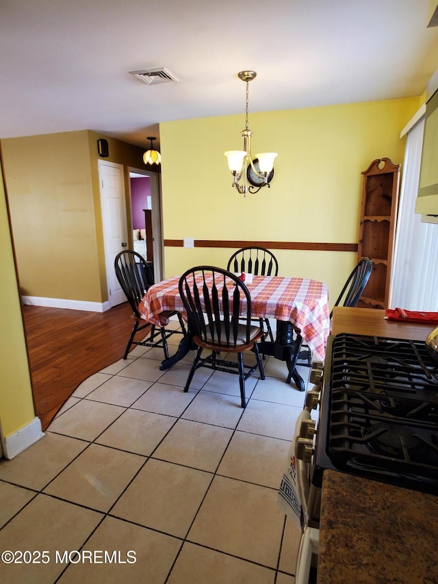 tiled dining room featuring a chandelier