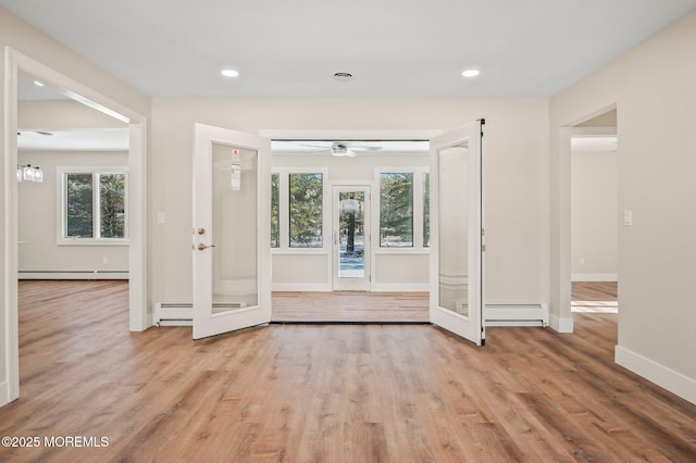 interior space featuring a healthy amount of sunlight, light hardwood / wood-style flooring, and a baseboard radiator