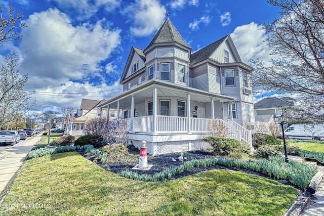 view of side of property with a porch and a lawn