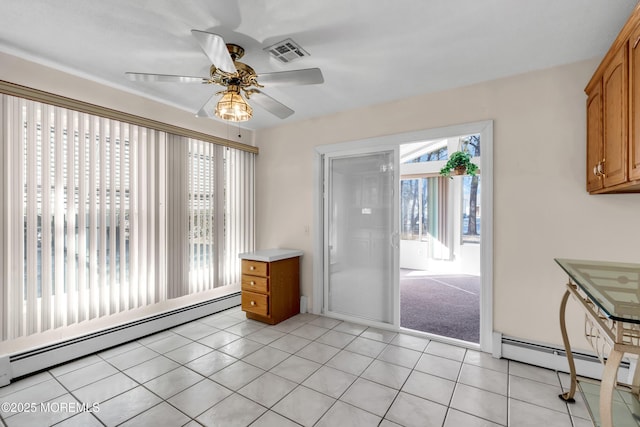 interior space featuring light tile patterned floors, ceiling fan, and baseboard heating