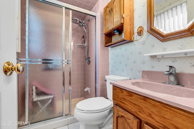 bathroom with tile patterned flooring, vanity, toilet, and a shower with shower door