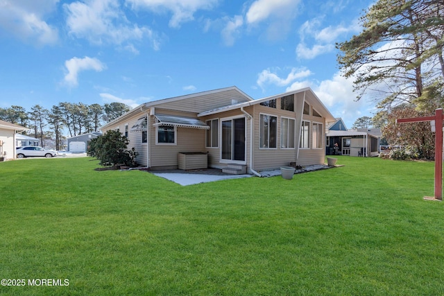 rear view of property featuring a lawn and a patio