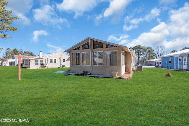 rear view of property with a yard and central AC unit