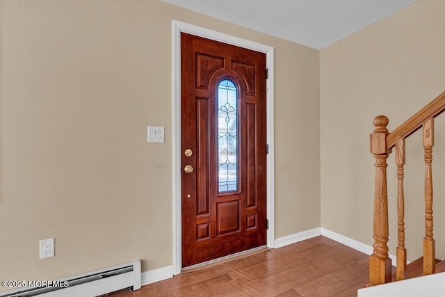 foyer entrance featuring baseboard heating and hardwood / wood-style floors