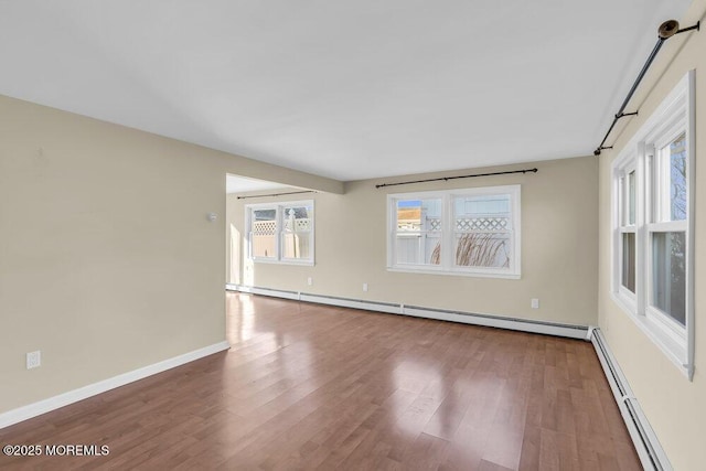 unfurnished room featuring hardwood / wood-style flooring and a baseboard radiator