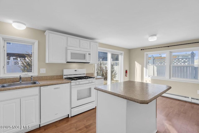 kitchen with white cabinetry, a center island, white appliances, light wood-type flooring, and sink