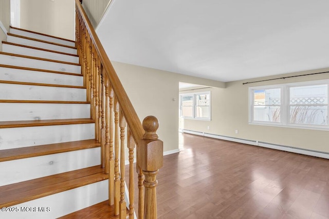 staircase featuring hardwood / wood-style floors and a baseboard radiator