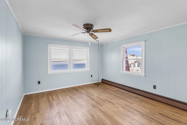 unfurnished room with ceiling fan, a wealth of natural light, light hardwood / wood-style floors, and a baseboard radiator