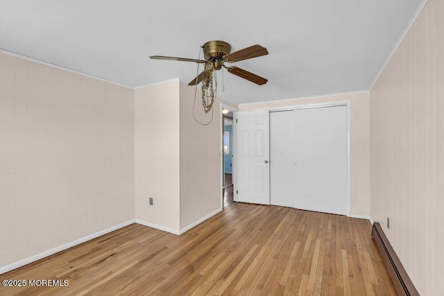 spare room featuring ceiling fan, a baseboard heating unit, light hardwood / wood-style flooring, and ornamental molding