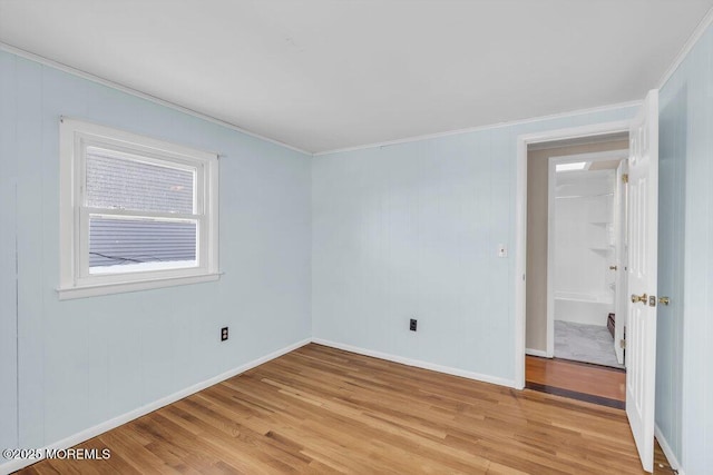 empty room with light wood-type flooring and ornamental molding