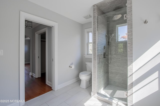 full bath with a stall shower, baseboards, toilet, and tile patterned floors