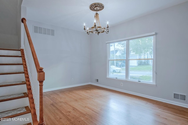 unfurnished room with wood finished floors, visible vents, and a healthy amount of sunlight