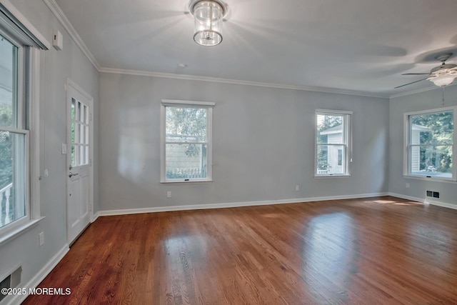 unfurnished room featuring plenty of natural light, baseboards, and wood finished floors