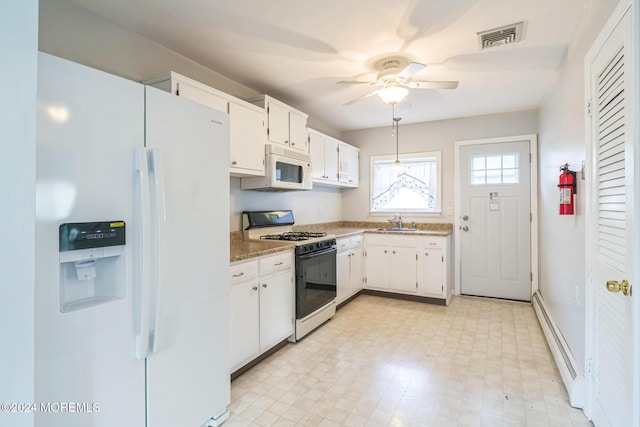 kitchen with white appliances, white cabinets, decorative light fixtures, sink, and stone counters