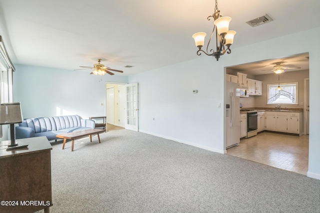 living room with ceiling fan with notable chandelier, light colored carpet, and sink