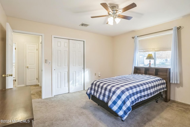 bedroom with light carpet, ceiling fan, and a closet