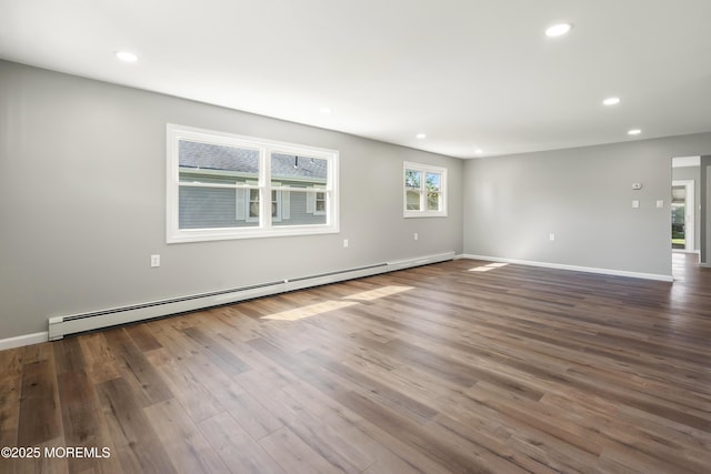 empty room with baseboard heating and hardwood / wood-style floors