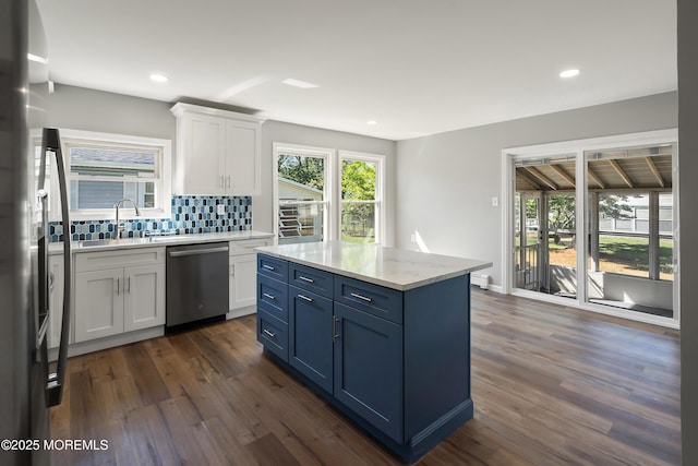 kitchen with light stone countertops, white cabinetry, stainless steel appliances, tasteful backsplash, and blue cabinetry