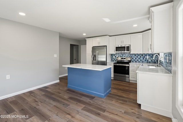 kitchen featuring white cabinetry, stainless steel appliances, dark hardwood / wood-style floors, a kitchen island, and sink