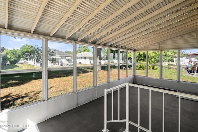 unfurnished sunroom featuring vaulted ceiling and a wealth of natural light